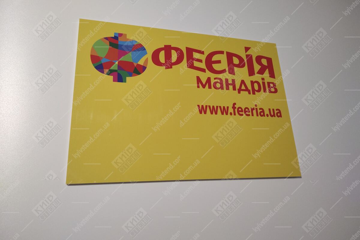 Настінна табличка туристичної агенції «Феєрія Мандрів» з фірмовим логотипом і URL feeria.ua