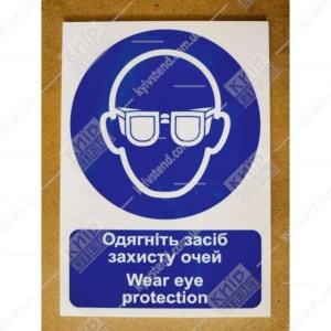 Знак безпеки Надягніть засіб захисту очей синього та білого кольору на пластиковій ламінованій основі  у виробничому приміщенні - фото знизу