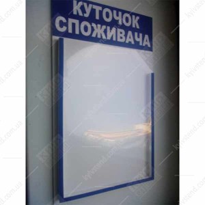 Куточок споживача біло синього кольору з однією обʼємною кишенею з ПВХ пластику, закріплений на стіні у приміщенні для обслуговування клієнтів - фото.