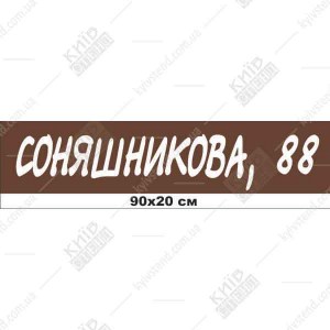 Пластикова адресна табличка 90 х 20 см коричневого кольору з білими літерами, встановлена на фасаді приватного будинку біля входу
