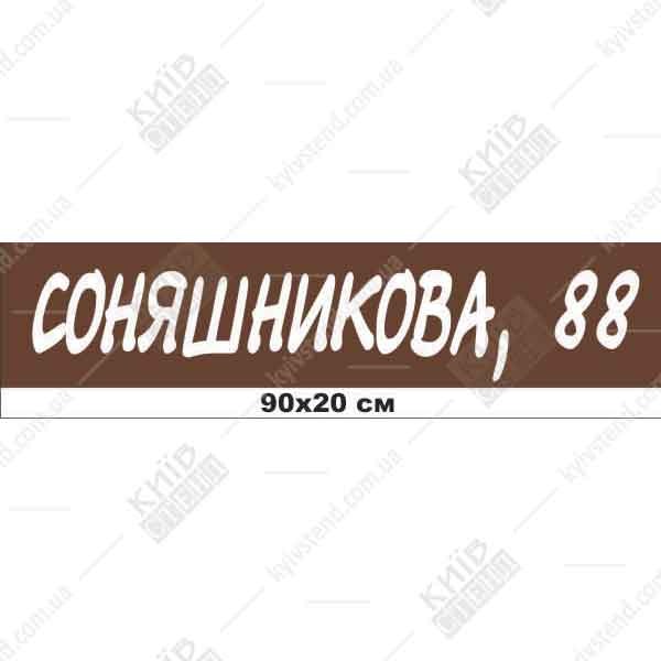 Пластикова адресна табличка 90 х 20 см коричневого кольору з білими літерами, встановлена на фасаді приватного будинку біля входу