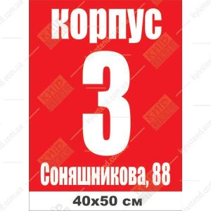 Адресна табличка на будинок з композиту темного кольору закріплена на фасаді приватного будинку