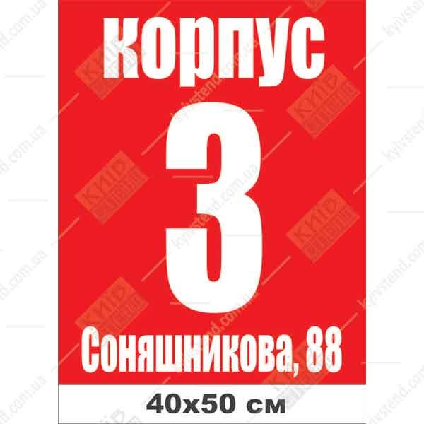 Адресна табличка на будинок з композиту темного кольору закріплена на фасаді приватного будинку