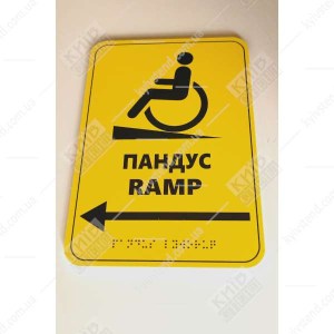 Фотографія знизу Тактильна табличка пандус з ПВХ 23х16 см з рельєфним шрифтом Брайля встановлена біля входу з пандусом.