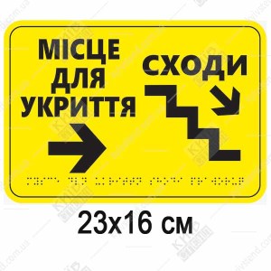 Тактильна табличка місце для укриття сходи вниз з білого ПВХ пластику встановлена біля сходів до укриття для навігації незрячих людей.